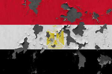 Close up grungy, damaged and weathered Egypt flag on wall peeling off paint to see inside surface.
