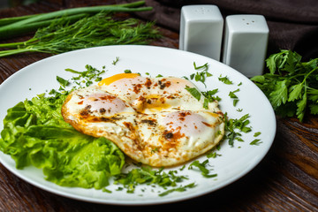 Flat lay of tasty breakfast over grey concrete table background. Fried eggs, micro greens, fresh tomatoes in plate, top view. Clean eating, dieting, vegetarian food - Image