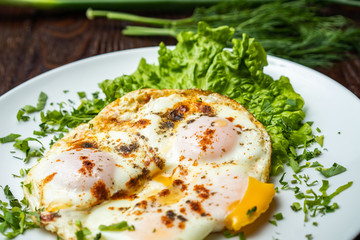 Flat lay of tasty breakfast over grey concrete table background. Fried eggs, micro greens, fresh tomatoes in plate, top view. Clean eating, dieting, vegetarian food - Image