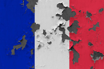 Close up grungy, damaged and weathered France flag on wall peeling off paint to see inside surface.