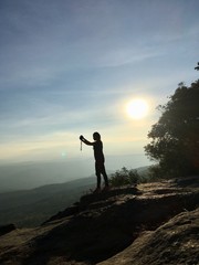 Silhouette woman taking photo with smartphone at mountain peak