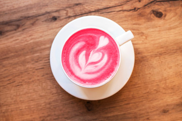 Cup of trendy beetroot latte on table.