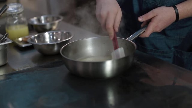 The cook prepares a duck with rice in the kitchen of the restaurant. Close-up without a face. Hands cook preparing duck with rice. The chef prepares the rice for the risotto