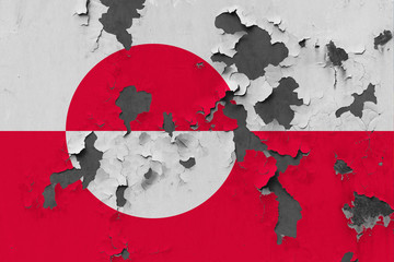 Close up grungy, damaged and weathered Greenland flag on wall peeling off paint to see inside surface.