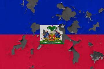Close up grungy, damaged and weathered Haiti flag on wall peeling off paint to see inside surface.