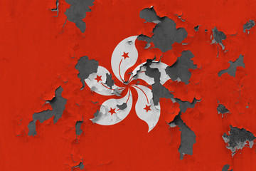 Close up grungy, damaged and weathered Hong Kong flag on wall peeling off paint to see inside surface.