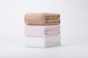 Stacked white, pink, apricot towels