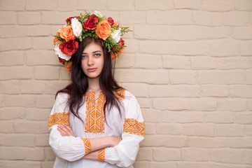 Portrait of a girl in an embroidered shirt and with a wreath on his head. Wreath is a traditional Ukrainian girl's headgear. Embroidered shirt - traditional Ukrainian clothes.