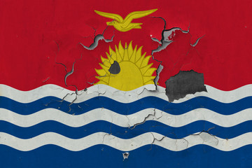 Close up grungy, damaged and weathered Kiribati flag on wall peeling off paint to see inside surface.