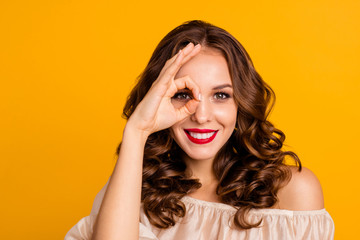 Close-up portrait of her she nice-looking attractive stunning magnificent winsome cheerful cheery wavy-haired lady showing ok-sign on eye isolated over bright vivid shine yellow background