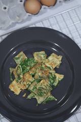 Warm Fried Eggs with Climbing Wattle in Black Dish