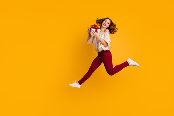 Full length body size view portrait of nice-looking attractive pretty sporty glad cheerful wavy-haired lady running carrying box isolated over bright vivid shine yellow background