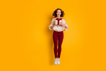 Full length body size view portrait of nice attractive lovely pretty glad cheerful cheery wavy-haired lady holding in hands festive box isolated over bright vivid shine yellow background