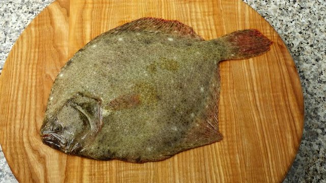 Fish of flatfish on a cutting board.