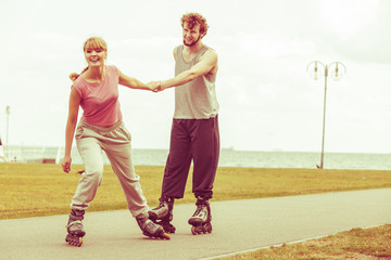 Woman encourage man to do rollerblading