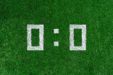 Football score 0:0.White numbers zero and zero are drawn on the green grass
