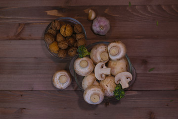 Fresh mushrooms, onion, nuts and garlic on wooden background 