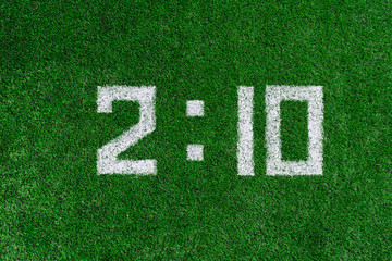 Football score.White numbers two and ten are drawn on the green grass