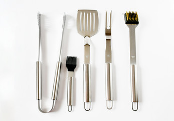 Top view object set of BBQ equipment stainless steel as tongs, carving fork, spatula in black bag . Isolated on a white background