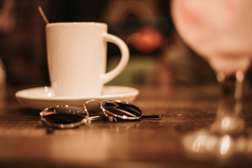 cup of coffee in a wooden pub with round sunglasses