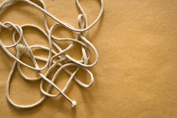 Tangled string on brown paper background.