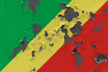 Close up grungy, damaged and weathered Republic Of The Congo flag on wall peeling off paint to see inside surface.