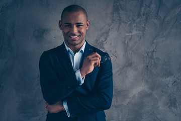 Close up photo portrait of attractive handsome smart clever intelligent nice in blue shirt lawyer real estate agent holding glasses for reading in hands isolated grey background