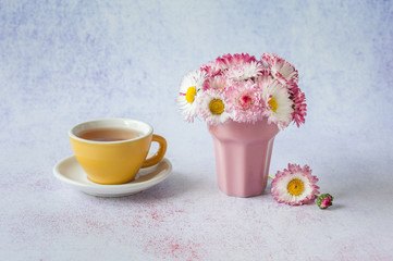 Cup of tea with daisies in vase. Spring concept. Minimalism, soft focus, place for text, close up.
