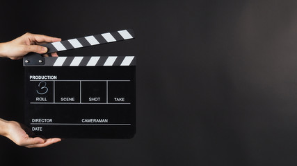 Hand is holding Black clap board or movie slate  use in video production , movie ,film, cinema...