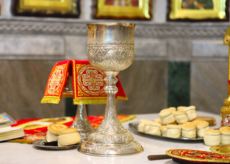 Orthodox Church. The priest covers the silver cup for communion, prospor on the throne.