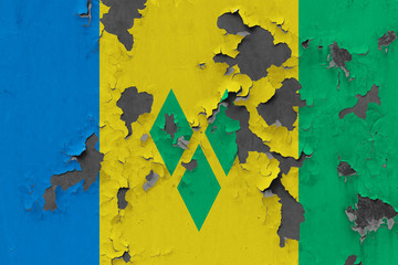 Close up grungy, damaged and weathered Saint Vincent And The Grenadines flag on wall peeling off...