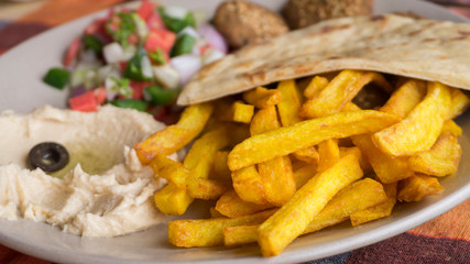 Closeup French fried with humus and pita plate