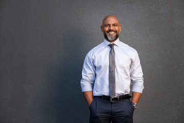 African american businessman smiling on grey - Powered by Adobe