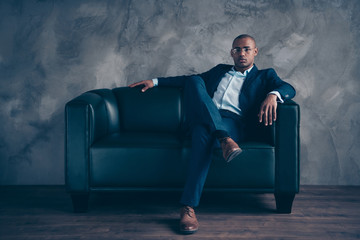 Portrait of his he nice classy chic attractive guy professional top manager ceo boss chief company director masculine sitting on couch at workplace station gray concrete wall