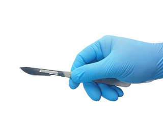 Hand of surgeon in blue medical glove holding a scalpel with blade isolated on white background...