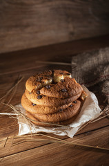 Fresh chocolate americana cookies on wooden table. Chocolate chip cookies on rural background.