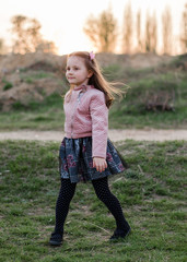 Cute child girl is walking near the river and forest. Outdoor. Spring forest