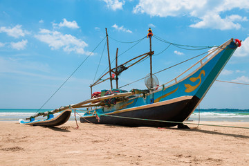 Fishing boat with nets on sandy ocean shore in asia.