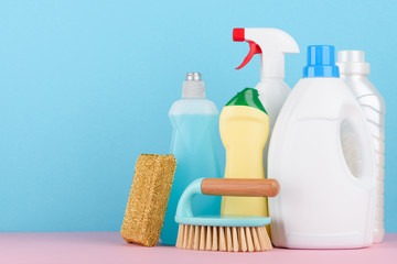 Cleaning service supplies on pastel background with copy-space.