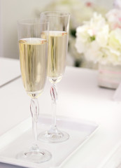 Two wedding glasses on a table with flowers