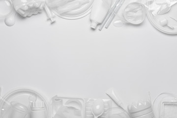 Single-use plastic objects, ecological pollution. Plastic waste. White packaging plastic products, top view flat lay border frame with copy-space.