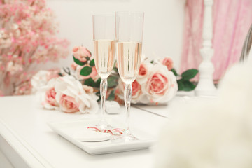Two wedding glasses on a table with flowers