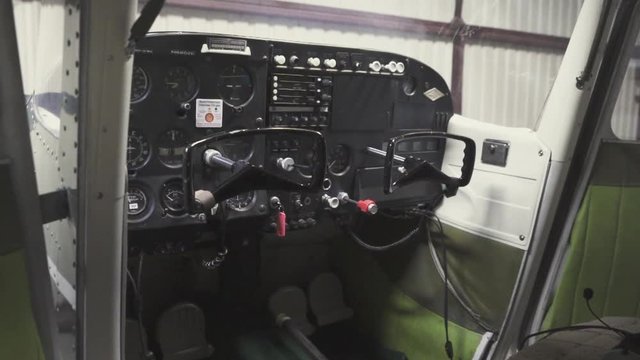 Zoom in to the control panel of a small plane parked inside a hangar for maintenance