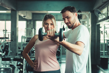 Portrait of Sporty Couple Love Exercised in Fitness Training With Dumbbell Equipment., Young Couple Caucasian are Working Out and Training Together in Gym Club. Sport Exercising and Healthy Concept