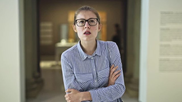 woman visitor in historical museum looking at art object