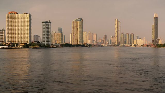 Time lapse zoon in 4K, During the evening, waterfront skyscraper in the center of Bangkok.