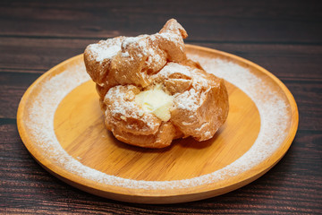 Choux Cream filled vanilla custard and dusted with icing.