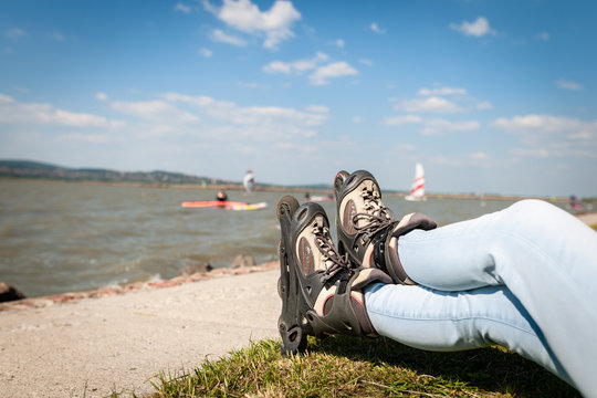 Close up picture of a woman legs wear inline roller blades near a strand of a lake