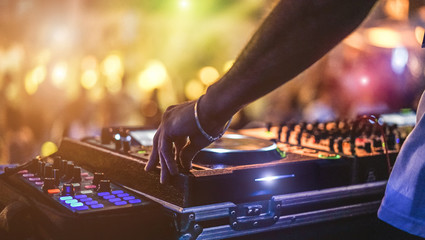 Dj mixing outdoor at beach party festival with crowd of people in background - Summer nightlife view of disco club outside - Soft focus on hand - Fun ,youth,entertainment and fest concept - obrazy, fototapety, plakaty