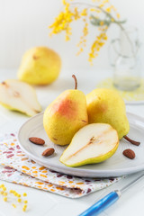 Delicious fresh and ripe Williams pears or Bartlett pears on a plate against light background. Still life shallow depth of field